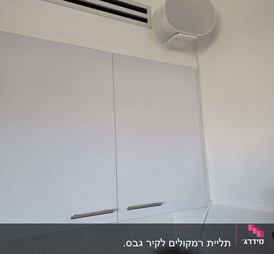 רמקול מותקן על קיר מעל ארונות מטבח